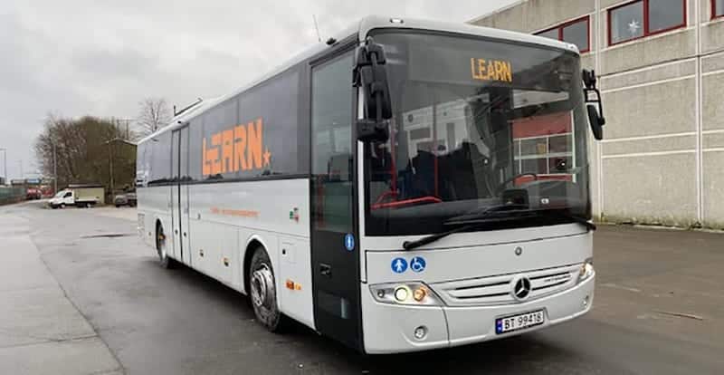 En hvit learn buss for FØRERKORT klasse D BUSS